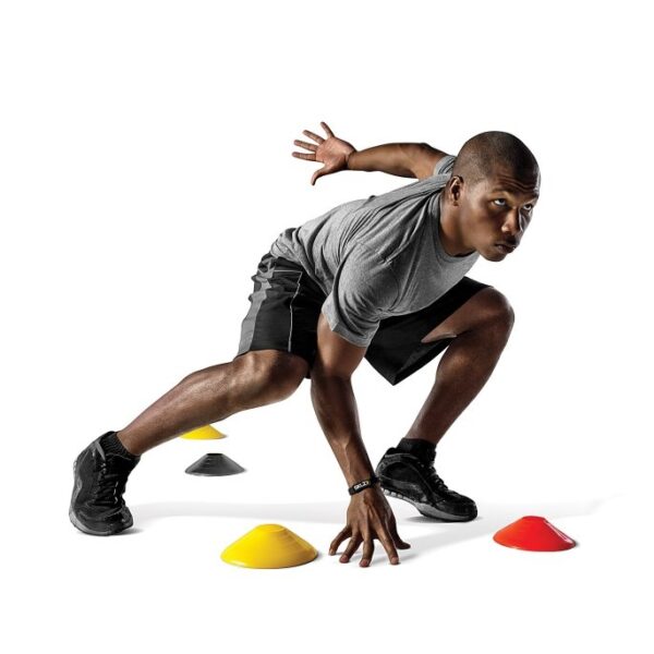 גבר אפרו אמריקאי מתאמן בעזרת כיפות סימון לאימון - Agility Cones