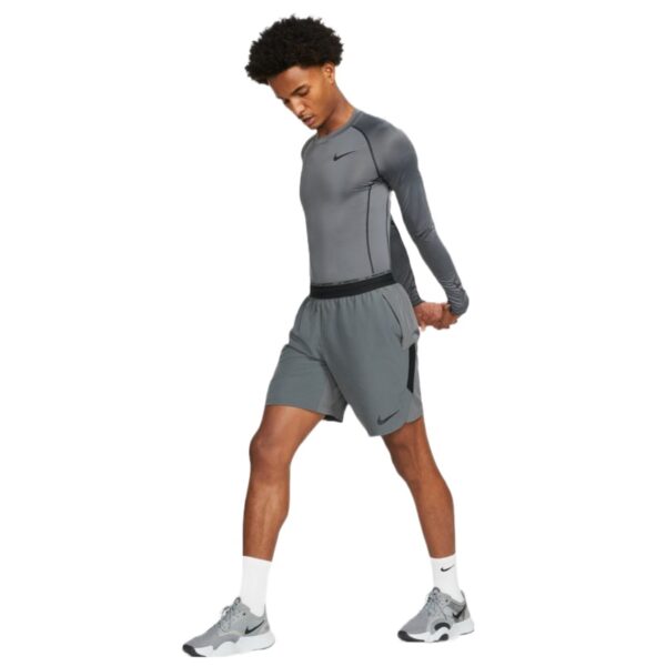 חולצת נייק אפורה צמודה לגברים עם שרוול ארוך Nike Pro Dri-FIT חולצה תרמית אפורה של נייק שרוול ארוך על דוגמן ספורטאי מבט מקדימה רחוק כל הגוף
