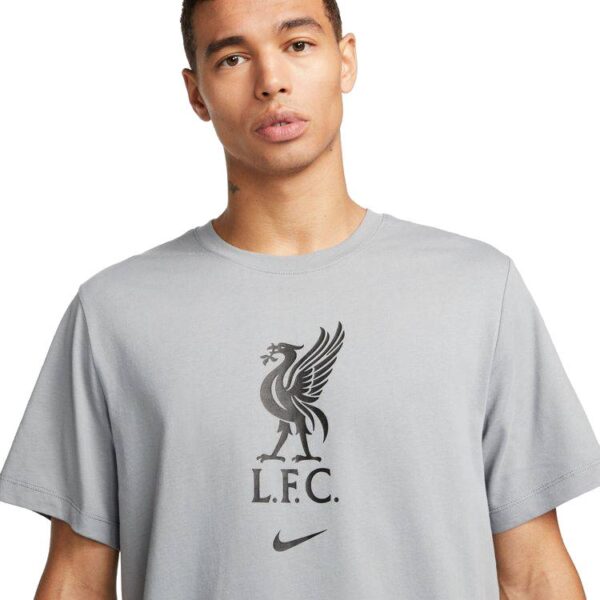 חולצת כדורגל גברים ליברפול NIKE - FC בצבע אפור בהיר תמונה מלפנים על דוגמן שזוף זום אין על הלוגו של הקבוצה