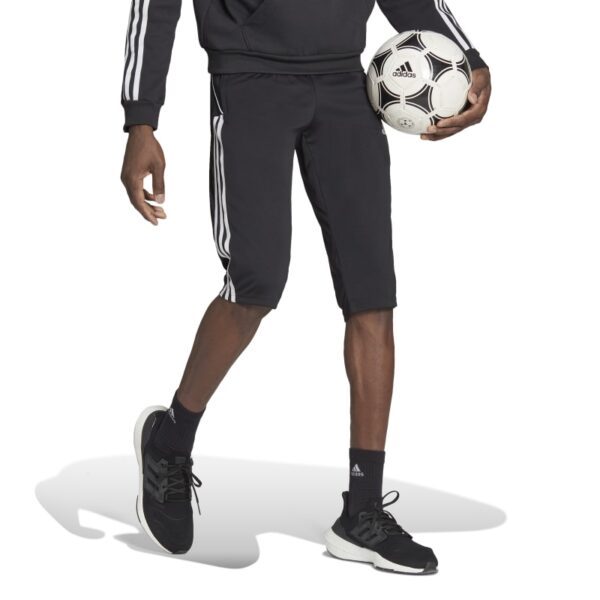 מכנס 3/4 גברים Adidas Tiro 23 League על כדורגלן כהה עור חצי גוף תחתון כדור ביד ימין הולך ימינה